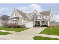 Beautiful two-story home featuring a well-manicured lawn and a charming front porch with stylish columns at 1443 Avondale Dr, Westfield, IN 46074