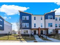 Inviting modern townhome featuring multi-tone siding, black fence, and a bright blue sky backdrop at 2945 Kirkbride Way, Indianapolis, IN 46222
