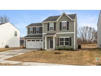 Two-story home featuring green siding, black shutters, a two-car garage and a well-manicured lawn at 3219 E Maygrove Dr, Danville, IN 46122
