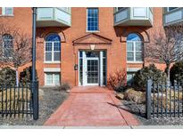 Beautiful condo entrance with glass door and brick facade. Balconies on upper floors with black iron fence at 402 E New York St # 302, Indianapolis, IN 46202