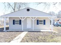 Charming home featuring blue shutters, a covered porch and updated neutral siding in a residential neighborhood at 4123 S Lynhurst Dr, Indianapolis, IN 46221