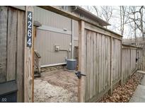 Small side yard behind a wooden gate, shows the side of the home and an A/C unit at 4264 Foxglove Trce, Indianapolis, IN 46237