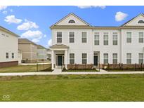 Charming two-story townhome featuring a well-manicured lawn and classic architectural details at 517 Steinbeck Pl, Carmel, IN 46032