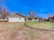 Charming one-story home with a white brick exterior, covered porch, and a well-manicured lawn at 6780 N Michigan Rd, Fairland, IN 46126