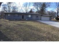 Charming single-story home featuring an attached garage and gravel driveway at 7144 Sandalwood Dr, Indianapolis, IN 46217