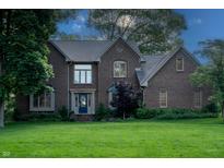 Charming two-story brick home featuring a well-manicured lawn and mature trees at 895 Baywood Ct, Columbus, IN 47201