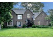 Charming two-story brick home with a well-manicured lawn and mature trees, showcasing classic architectural details at 895 Baywood Ct, Columbus, IN 47201