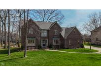 Charming brick two-story home featuring lush green lawn and mature trees at 895 Baywood Ct, Columbus, IN 47201