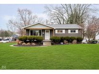 Charming single-story home with well-manicured front lawn and decorative bushes at 900 W Oak St, Zionsville, IN 46077