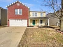 Charming two-story home with brick facade, white garage door, and inviting front porch at 10904 Cyrus Dr, Indianapolis, IN 46231