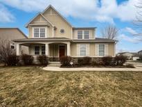 Charming two-story home featuring a covered porch, landscaped yard, and a mix of stone and stucco facade at 11134 Westoves Dr, Noblesville, IN 46060
