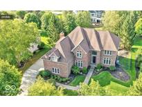 Stunning aerial view of a brick home surrounded by lush landscaping and mature trees at 13133 Brooks Landing Pl, Carmel, IN 46033