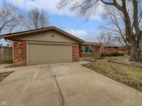 Cozy single-story brick home featuring an attached garage and a concrete driveway at 1825 E 49Th St, Anderson, IN 46013
