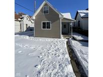 Charming home featuring a covered porch and snow-covered front yard at 2133 Webb St, Indianapolis, IN 46225