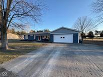 Charming single-story home with a wide driveway, a two-car garage, and a welcoming red front door at 2169 W State Road 234, Fortville, IN 46040