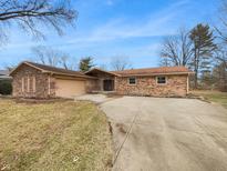 Charming brick ranch home featuring an attached two car garage and concrete driveway at 310 Hickory Dr, Greenfield, IN 46140