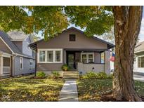 Charming home showcasing a landscaped front yard, inviting porch and traditional architectural design at 4818 Guilford Ave, Indianapolis, IN 46205