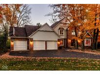 Charming home with a three car garage, brick accents and a well manicured yard, surrounded by beautiful fall foliage at 5015 Watersite Cir, Indianapolis, IN 46254