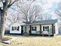 Charming home with a covered porch and beautiful landscaping at 504 S Main St, Waldron, IN 46182