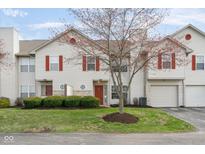 Charming townhome featuring red shutters, front lawn with manicured bushes, and an attached garage at 6014 Wildcat Dr, Indianapolis, IN 46203