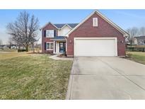 Charming two-story brick home with an attached two car garage and a well-manicured front lawn at 7213 Shag Oak Dr, Noblesville, IN 46062