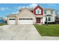 Charming brick and siding home featuring a three-car garage, well-manicured lawn, and inviting front entrance at 8238 Armadale Ct, Indianapolis, IN 46236