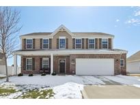 Traditional two-story home with brick and siding exterior, featuring a two-car garage and covered front porch at 8517 Hornady Dr, Indianapolis, IN 46239