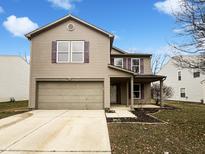 Charming two-story home featuring a two-car garage and neutral siding under a bright blue sky at 976 Peppermint Ct, Greenfield, IN 46140