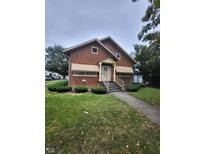 Charming brick home featuring a well-maintained lawn, inviting entryway, and complementary landscape accents at 1001 S Anderson St, Elwood, IN 46036