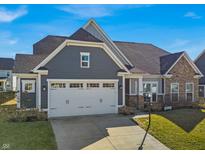Charming two-story home with gray siding, stone accents, and a spacious two-car garage at 1243 Heartland Dr, Westfield, IN 46074