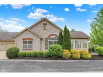 Charming stone home featuring a beautiful brick arch above the large window and manicured landscaping at 13902 Rue Royale Ln # 62, McCordsville, IN 46055