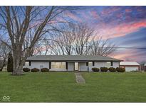 Charming single-story home with a well-manicured lawn, mature trees, and a detached garage at 1979 W Gordon Rd, Mooresville, IN 46158