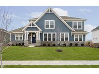 Charming two-story home with blue siding, stone accents, manicured lawn, and inviting front entrance at 203 Chatham Bend Dr, Westfield, IN 46074