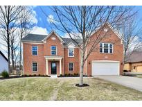 Charming two-story brick home featuring an attached two-car garage and a well-manicured front lawn at 21241 Carlton Ct, Noblesville, IN 46062