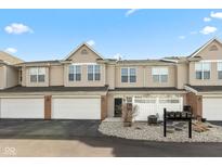 Charming townhouse featuring a two-car garage and welcoming curb appeal with neutral siding and a well-maintained landscape at 2218 Colfax Ln, Indianapolis, IN 46260