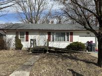 Charming home featuring red shutters, an attached garage and ramp access for convenience at 308 Mohawk St, Anderson, IN 46012