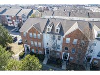 Aerial view of a brick townhouse complex with neat landscaping and a gray shingle roof at 427 Windham Pass, Carmel, IN 46032
