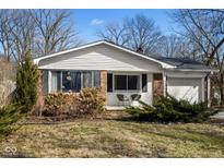 Charming one-story brick home with well-maintained lawn and cozy front porch with seating at 4559 Bonnie Brae St, Indianapolis, IN 46228