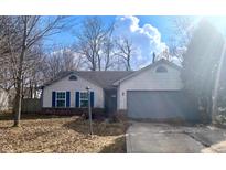 Charming single-story home featuring a two-car garage, blue shutters, and a well-lit lamp post on a sunny day at 5289 Pine Hill Dr, Noblesville, IN 46062