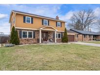 Charming two-story home featuring a brick and siding exterior, complemented by a well-manicured lawn and mature landscaping at 5529 W 29Th Pl, Indianapolis, IN 46224