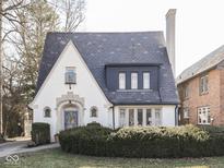 Charming home with a beautiful slate roof, arched doorway, and manicured landscaping creating curb appeal at 6009 N Washington Blvd, Indianapolis, IN 46220