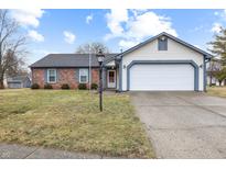 Charming one-story home with brick accents, a two-car garage, and well-maintained lawn at 7463 Pebblebrooke W Dr, Indianapolis, IN 46236