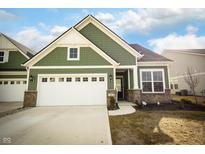Charming green home featuring a brick foundation and an attached two-car garage and long drive at 761 Stone Trace Ct, Avon, IN 46123
