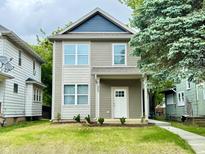 Charming two-story home with a well-maintained lawn and inviting front entrance at 857 N Oakland Ave, Indianapolis, IN 46201