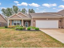 Charming brick ranch home featuring a manicured lawn, flower beds and an attached two car garage at 8727 Faulkner Dr, Indianapolis, IN 46239