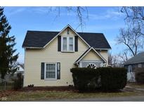 Charming two-story home with light yellow siding, black roof and shutters at 1228 E Perry St, Indianapolis, IN 46227