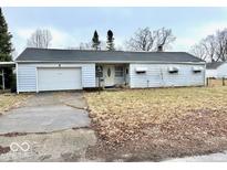 A single-story home with a one-car garage and a small front yard in need of maintenance at 2513 W 10Th St, Muncie, IN 47302
