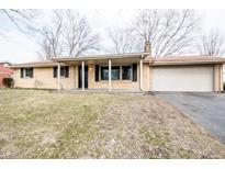 Charming single-story brick home featuring a covered front porch and attached two-car garage at 3911 N Tudor Ct, Columbus, IN 47201