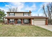 Charming two-story home with a brick facade, tan siding, well-manicured lawn, and an attached two-car garage at 3968 Creekwood Dr, Greenwood, IN 46142