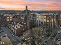 Expansive aerial view of a brick condominium complex with a water tower and colorful dusk sky at 611 N Park Ave # 414, Indianapolis, IN 46204